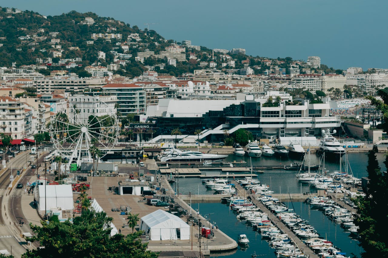 Scenic aerial shot of Cannes harbor with yachts and cityscape, capturing the essence of the French Riviera.